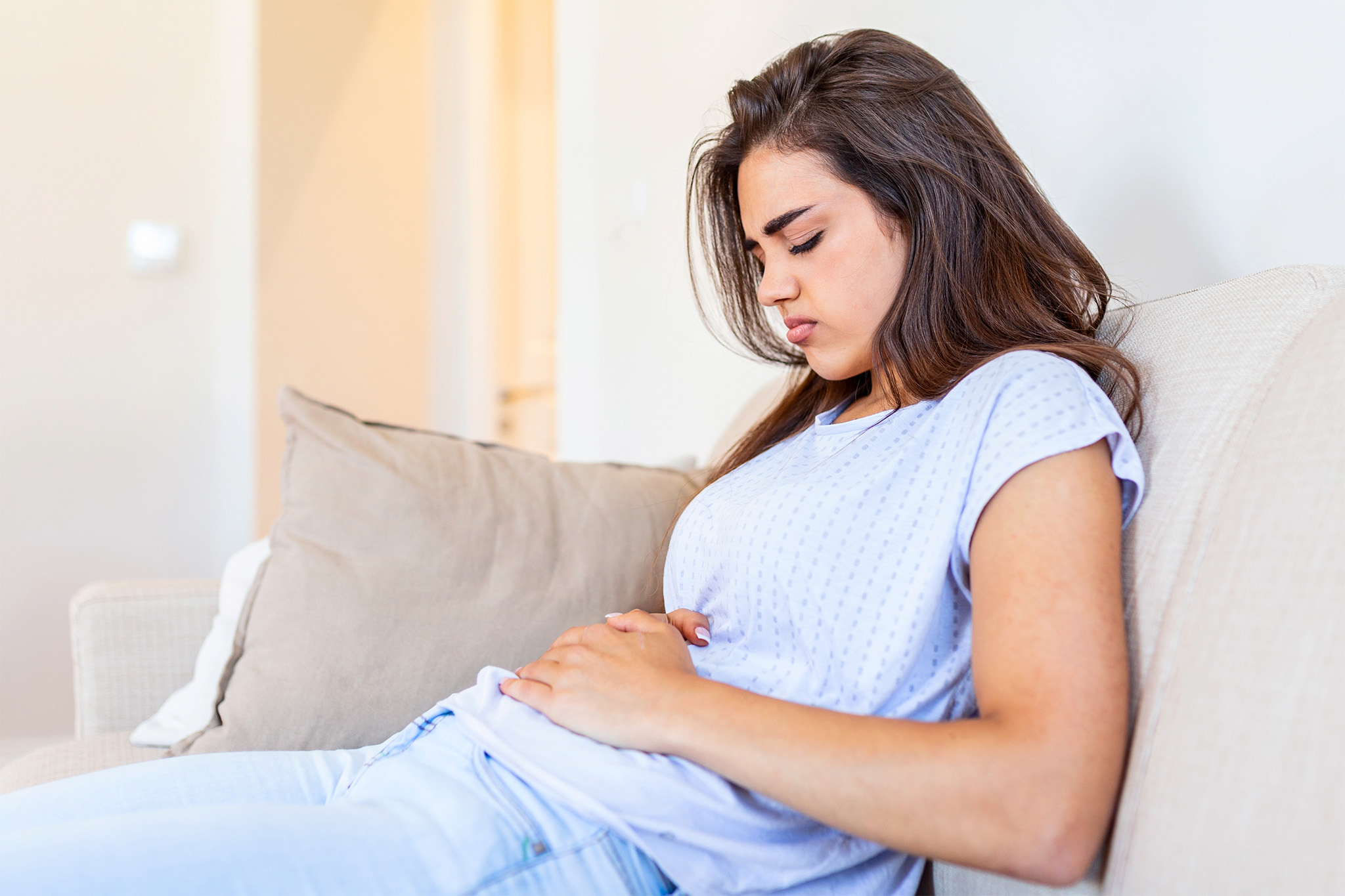 Girl with abdominal pain clutching her stomach