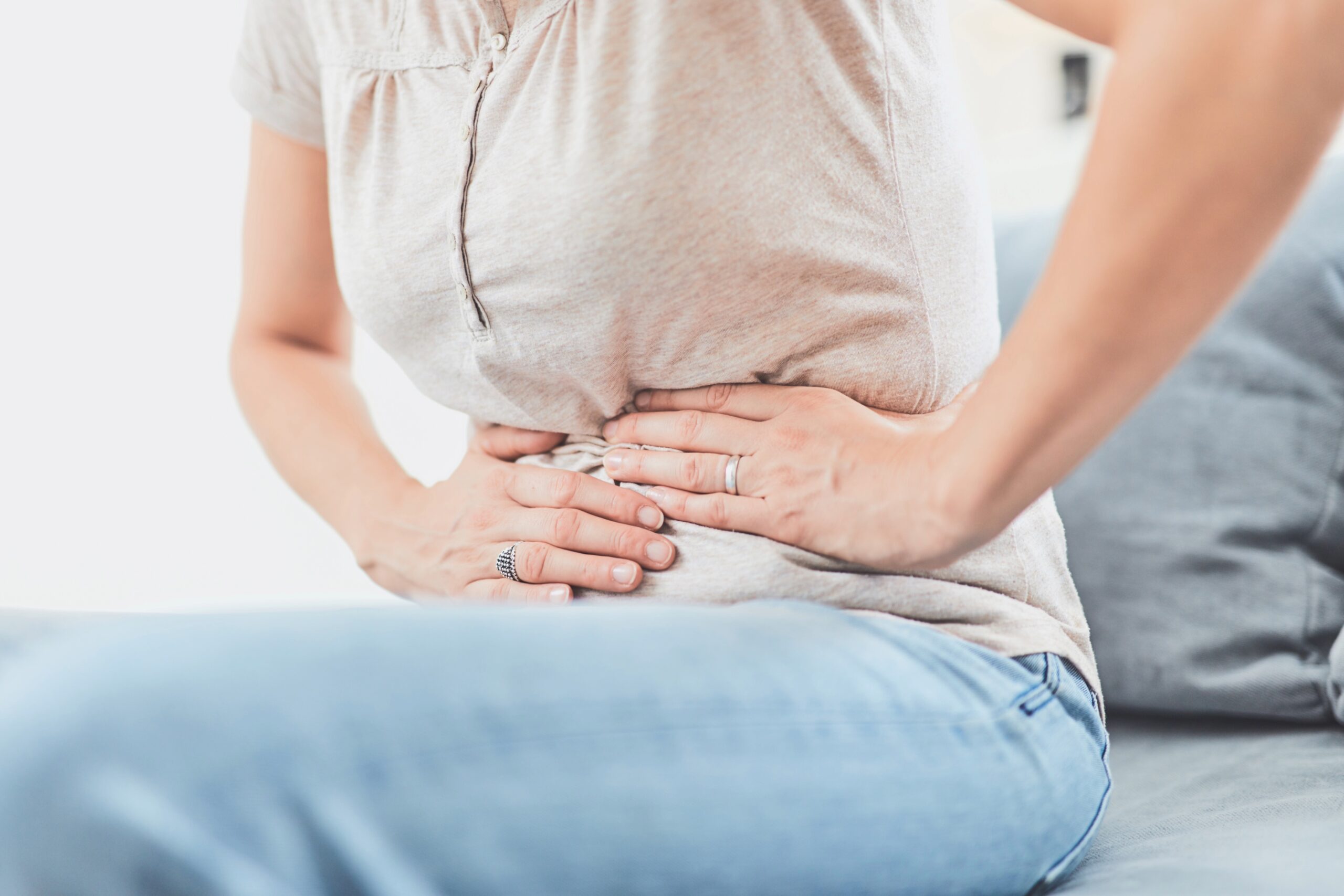 Woman with abdominal pain is pressing on her stomach with her hands